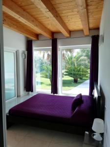 um quarto com uma cama roxa em frente a uma janela em Villa Belvedere Degli Ulivi em Osimo
