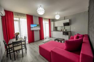 a living room with a red couch and a table at TABU Residence in Mamaia Nord