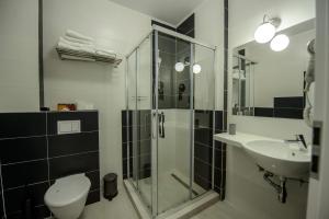 a bathroom with a shower and a toilet and a sink at TABU Residence in Mamaia Nord +31 photos