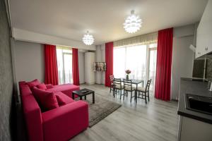 a living room with a red couch and a table at TABU Residence in Mamaia Nord