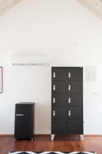 eine schwarze Kommode und ein schwarzer Kühlschrank in einem Zimmer in der Unterkunft Ćiri Biri Bela Private dorm in Split