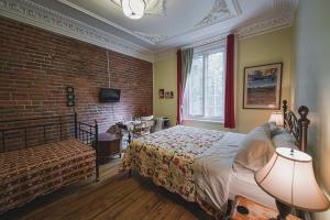 um quarto com uma cama e uma parede de tijolos em À l'Adresse du Centre-Ville em Montréal