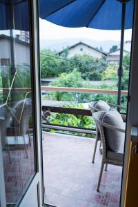 比哈奇的住宿－Apartman Nisa，通往带椅子和遮阳伞的阳台的开放式门
