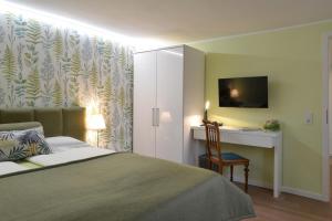 Schlafzimmer mit einem Bett, einem Schreibtisch und einem TV in der Unterkunft Gästehaus A und D Fischer in Mörfelden-Walldorf