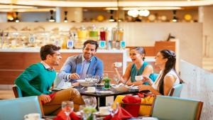 a group of people sitting around a table in a restaurant at Barceló Mexico Reforma in Mexico City