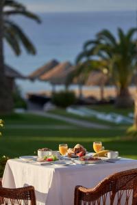 a white table with food and drinks on it at Hotel Porto Santo & Spa in Porto Santo