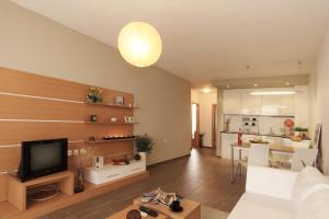 a living room with a white couch and a television at View Apartments in Sozopol