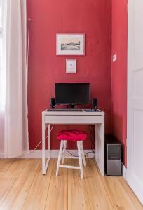 a desk with a computer on a red wall at Bahnhof Frauenstein Wartehalle in Frauenstein