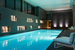 a pool in a room with a chair and a couch at Heliopic Hotel & Spa in Chamonix-Mont-Blanc
