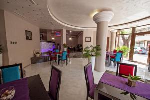 a dining room with purple and blue tables and chairs at Hotel Perfect in Varna City