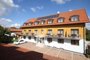 a large building with a car parked in front of it at Hotel Pension Fleischmann in Roding