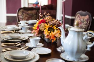 a table with plates and a vase with flowers on it at The Bevin House B&B in East Hampton