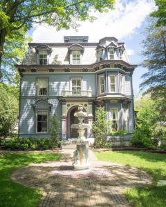 an old house with a fountain in front of it at The Bevin House B&B in East Hampton