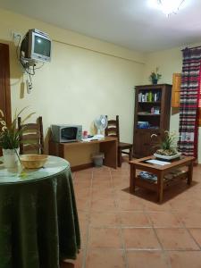 een woonkamer met een tafel en een televisie bij Hostal Pampaneira in Pampaneira