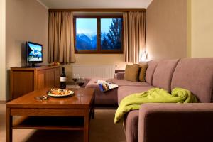 a living room with a couch and a table at Hotel Rozsutec in Terchová