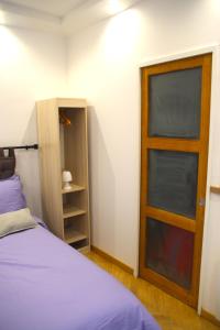 - une chambre avec un lit et une porte en bois dans l'établissement Le Poissonnière, à Paris