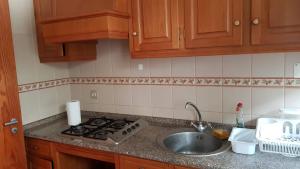 um balcão de cozinha com um lavatório e um fogão em Dunas House em Giz