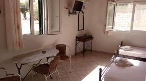 a living room with a table and chairs and a sink at Rania Studios in Lefkada