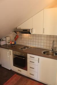 察夫塔特的住宿－Apartments Marlais，厨房配有白色橱柜、炉灶和水槽。