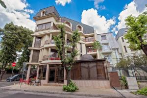 a building with a tree in front of it at Hotel Perfect in Varna City