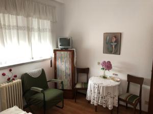 un soggiorno con tavolo, sedie e TV di Residencia Maria Jose a Fátima