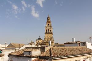 a tall building with a clock tower in a city at AL-ANDALUS: Juderia, Mezquita in Córdoba