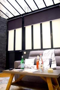 a table with bottles on it in a room with windows at Le Poissonnière in Paris