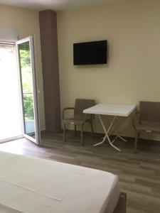 a room with a bed and a table and a tv at Hotel Eduard in Shëngjin