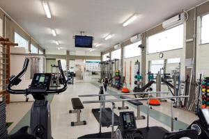 a gym with treadmills and cardio equipment and a tv at Hotel Ema Palace in São José dos Campos