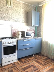 キリルロフにあるSimonovskayaのキッチン(青いキャビネット、コンロ、電子レンジ付)