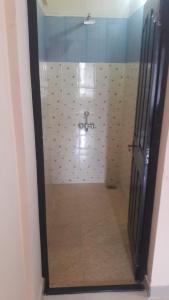 a bathroom with a shower with a toilet in it at Bennies Inn in Kottayam