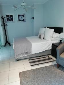 um quarto com uma cama e uma parede azul em The Palm in Pinelands em Cidade do Cabo