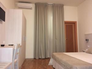 a bedroom with a bed and a desk and a window at Hotel La Pace in Pontedera