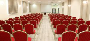 pusty pokój z czerwonymi krzesłami i ekranem w obiekcie Hotel Forum Fitness Spa & Wellness w mieście Lublin