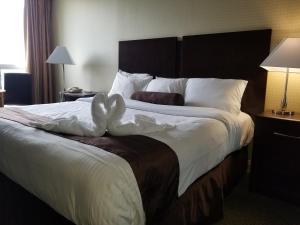 a bed with a white comforter and pillows at The Oakes Hotel Overlooking the Falls in Niagara Falls