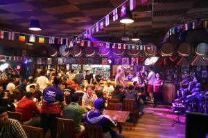 a crowd of people sitting in a bar at Arena Living in Sanur