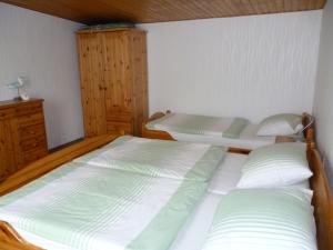 ユッケリッツにあるHaus Frohsinnのベッドルーム1室(ベッド2台、木製キャビネット付)