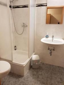 La salle de bains est pourvue d'une douche, d'un lavabo et de toilettes. dans l'établissement Hotel Merkur Garni, à Sarstedt