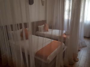 a bedroom with two beds and a window with curtains at The Vic Hotel in Kisumu