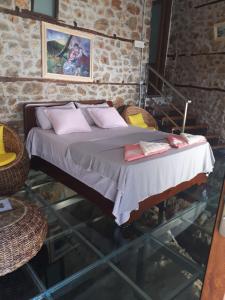 um quarto com uma cama com almofadas em Nuci's Home glass floor em Tushemisht