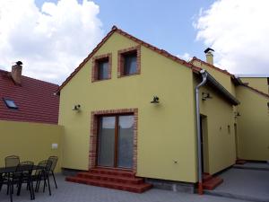 a yellow house with a table and chairs at Apartmány Hradiště in Znojmo