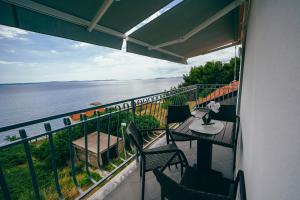 a balcony with a table and chairs and the ocean at Apartmani Josip in Podstrana