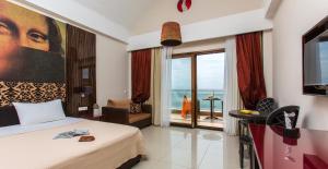 a hotel room with a bed and a view of the ocean at Olympion Sunset Halkidiki in Fourka