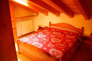 AlleinにあるMaison de Freinのベッドルーム1室(木製ベッド1台、赤と白のベッドカバー付)