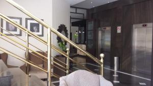 a lobby with a staircase with gold railings at Gran Hotel Toloma in Cochabamba