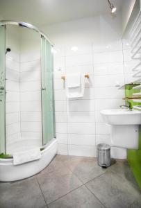 a bathroom with a shower and a sink and a toilet at Hotel Arsenał in Gliwice +30 photos