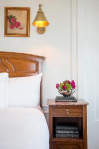 a bed with a table with a bowl of flowers on it at The Culver Hotel in Los Angeles