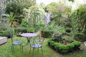 ナントにあるLa Tropicale- Chambre d'hôte au calmeの植物庭園のテーブルと椅子