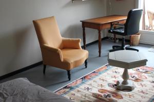una camera da letto con scrivania, sedia e scrivania di La Tropicale- Chambre d'hôte au calme a Nantes