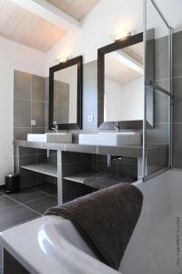 a bathroom with two sinks and a mirror at villas des phares in La Flotte
